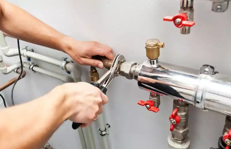 Professional commercial plumber working in a restaurant kitchen